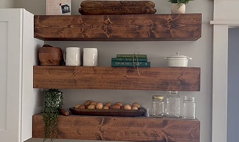 Woman cutting up wood for floating shelves